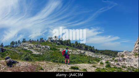 Frau Walker, Wanderer, in kurzen Hosen, mit Rucksack und blauer Himmel mit Zirruswolken Stockfoto