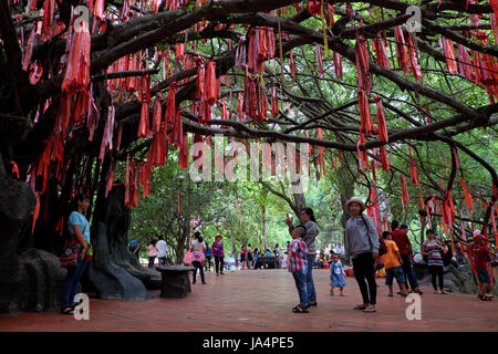 HO CHI MINH CITY, VIET NAM-1. Juni 2017: Leute hängen rote Schleifen auf Liebe Baum bei Suoi Tien Touristengebiet, Platz für kulturelle Reisen, Vietnam Stockfoto