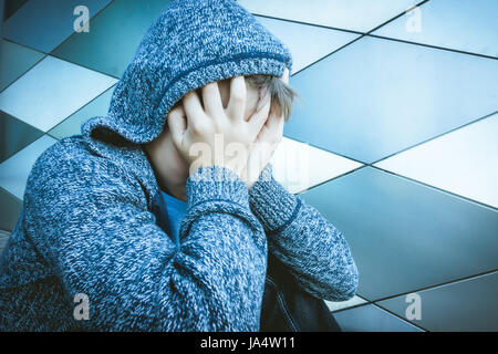 Traurig, einsam, unzufrieden, enttäuscht Kind hält Kopf mit Händen Stockfoto