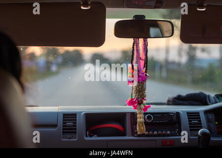 Ein alltäglicher Anblick in Thailand. Phuang Malai - eine Blumengirlande verkauft für Glück hängen nach unten aus dem Rückspiegel in einem Taxi. Stockfoto