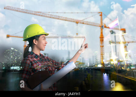 Frauen Asien Ingenieur arbeiten und halten Blaupausen auf Baustelle Stockfoto