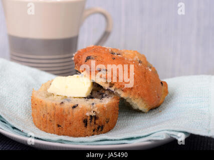 Köstliche warme Blueberry Muffin, serviert mit Butter und eine Tasse Kaffee Stockfoto