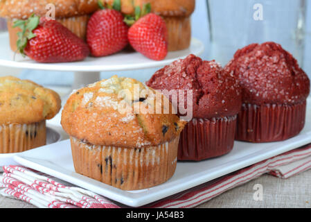 Große Auswahl an köstlichen Frühstück Muffins serviert auf Platten mit Erdbeeren Stockfoto