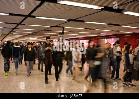 Horizontale Ansicht von Pendlern Rauschen entlang der Bahnhofshalle von der MTR, mass Transit Railway, in Hong Kong, China. Stockfoto