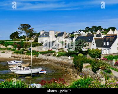 Cottages entlang der Küstenlinie von Île de Batz, Frankreich im Nordwesten der Bretagne an einem sonnigen, blauen Himmelstag. Stockfoto