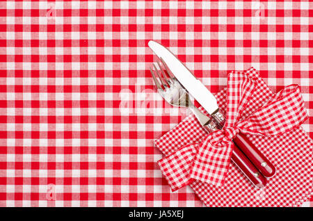 ein Tisch gedeckt mit Besteck und Serviette in rot und weiß Stockfoto