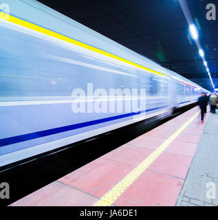 Bahnhof, Zug und Lichter verschwommen durch die unglaubliche Geschwindigkeit, Zug Plattform in Poznan, Polen. Nacht erschossen. Stockfoto