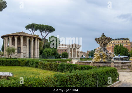 Tritonen-Brunnen und Tempel des Hercules Victor (Tempio di Ercole Vincitore) auf dem Forum Boarium am Piazza Bocca della Verita (Mund der Wahrheit) - R Stockfoto