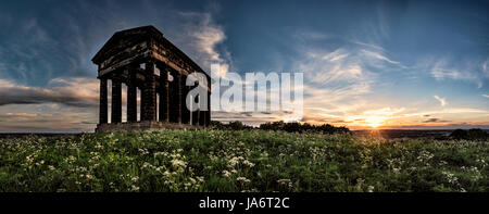 Die Sonne untergeht hinter dem Penshaw Monument, einer halbgroßen Nachbildung des Tempels des Hephaestus in Athen. Das Denkmal steht auf einem Hügel in Sunderland im Nordosten Englands und wurde zu Ehren von Lord Lambton, dem damaligen Parlamentsabgeordneten, errichtet. Stockfoto