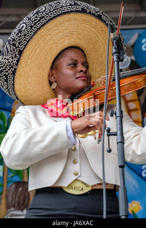 Live-Musik. Mariachi-Geigerin, dunkelhäutige junge Musikerin, die einen mexikanischen Mariachi-Sombrero trägt, gekleidet mit traditioneller mexikanischer Mariachi-Kleidung. Stockfoto