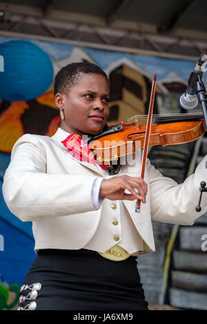 Live-Musik. Mariachi-Geigerin, dunkelhäutige junge Musikerin, die einen mexikanischen Mariachi-Sombrero trägt, gekleidet mit traditioneller mexikanischer Mariachi-Kleidung. Stockfoto