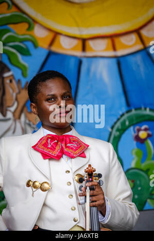 Live-Musik. Mariachi-Geigerin, dunkelhäutige junge Musikerin, die einen mexikanischen Mariachi-Sombrero trägt, gekleidet mit traditioneller mexikanischer Mariachi-Kleidung. Stockfoto