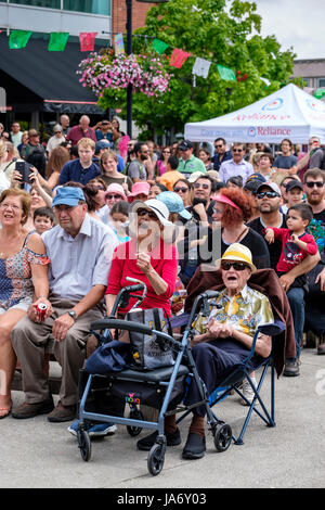 Alter älteres Ehepaar, das Spaß auf einem Musikfestival hat, männliche und weibliche Senioren tragen Strohhüte und Sonnenbrille, klatschen auf den Klang der Musik, genießen sich, Spaß haben, Outdoor-Aktivitäten, Menschenmenge, London, Ontario, Kanada. Stockfoto