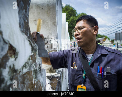 August 24, 2017 - Bangkok, Bangkok, Thailand - Bangkok City Mitarbeiter verfügt über ein Abstreifer alte Farbe und Schmutz von den Wänden der Pom Mahakan zu entfernen. Die Stadt Bangkok Beamte diese Woche begonnen, reinigen Sie den Bereich um die einäscherung site für Bhumibol Adulyadej, der verstorbene König von Thailand. Arbeit durch Reinigung Pom Mahakan, einer historischen Fort etwa zwei Kilometer nordöstlich der Einäscherung Standort gestartet. Sie werden zu Scheuern und historischen äußeren Mauern der Festung, die im späten 18. Jahrhundert errichtet wurden. Der König, der am 13. Oktober 2016 starb, wird am 26. Oktober 2017 verbrannt zu werden. (Bild: © Jack Ku Stockfoto