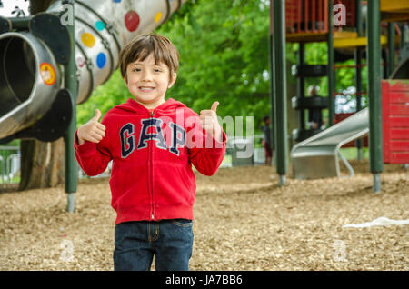 Ein junges Kind spielen auf dem Kinderspielplatz im Prspect Park, lesen. Stockfoto