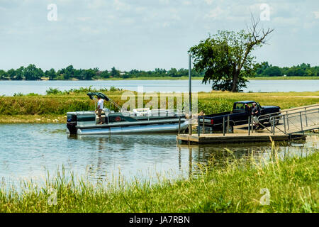 Zwei Männer laden ein Ponton-Boot auf einen Bootsanhänger nach dem Angeln auf Overholser See in Oklahoma City, Oklahoma, USA. Stockfoto