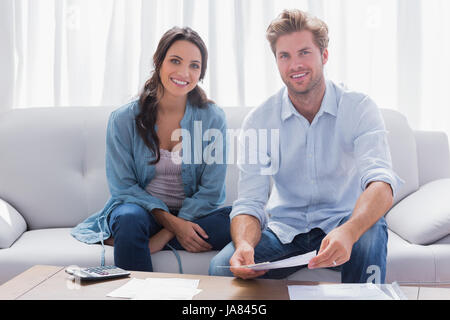 Glückliches Paar tun ihre Konten in einer Couch saß Stockfoto