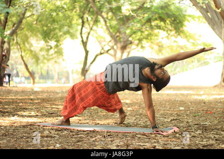 Junge indische Yoga-Pose durchführen. Wilde Sache darstellen. chamatkarasan Stockfoto