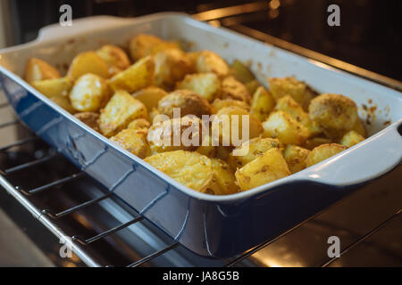 Nahaufnahme auf Backkartoffeln mit Kurkuma und anderen Gewürzen in der Pfanne rösten. Tiefenschärfe, Seitenansicht Stockfoto