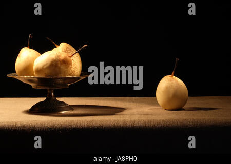 Vintage Messing Obstschale mit Birnen auf Leinwand Oberfläche Stockfoto