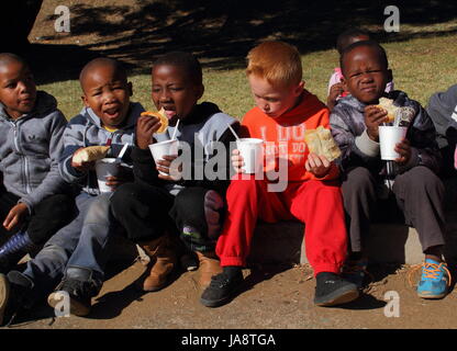 Johannesburg-Südafrika - erhalten nicht identifizierten bedürftige Schulkinder Brot und Suppe von einer privaten nichtstaatliche Wohltätigkeitsorganisation Fütterung Schema Stockfoto