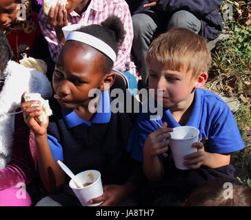 Johannesburg-Südafrika - erhalten nicht identifizierten bedürftige Schulkinder Brot und Suppe von einer privaten nichtstaatliche Wohltätigkeitsorganisation Fütterung Schema Stockfoto