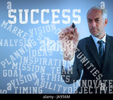 Attraktive Geschäftsmann schreiben Erfolg Begriffe mit einem Marker vor blauem Hintergrund Stockfoto