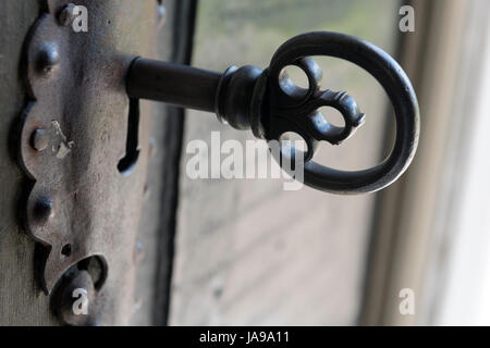 Nahaufnahme eines alten Metallschlüssels in einem antiken Türschloss, das alte Handwerkskunst und Details zeigt Stockfoto