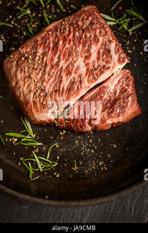 Rohe Wagyu Striploin Rindersteak mit Pfeffer auf dunkle Schale hautnah. Restaurant Stockfoto
