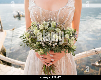 Blumenstrauß in der Hand der Braut mit viel Grün Hochzeit Stockfoto