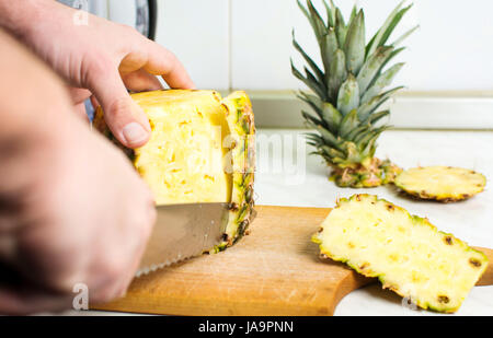 Männliche Hände frische Ananas Haut peeling hautnah Stockfoto