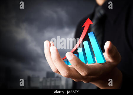 Hand, die einen steigenden Pfeil für Unternehmenswachstum Stockfoto