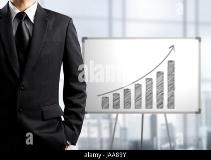 Business-Mann stehend und Zeichnung Wachstumsdiagramm auf weißen Tafel, Erfolgskonzept Stockfoto