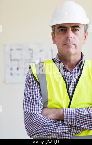 Portrait des Architekten tragen Schutzhelm mit Plänen im Hintergrund Stockfoto