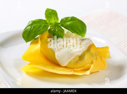 Spinat und Ricotta gefüllte Pasta serviert mit weißen Sahne-Sauce und geriebenem Parmigiano Stockfoto