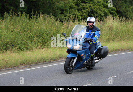 Einem französischen Gendarmerie Motorradfahrer fahren entlang einer britischen Straße in Phase 3 der Tour de France im Jahr 2014. Stockfoto