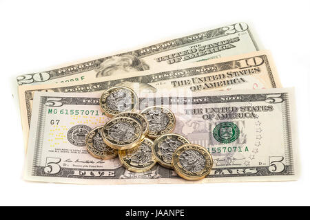 Ein Pfund Münzen über US-Banknoten gelegt Stockfoto