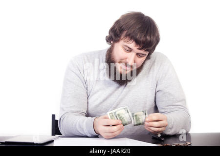 Geld glücklich nicht kaufen. Close Up Portrait junger Mann Geld Bargeldhaltung, menschliche befasst sich mit Bargeld, am Tisch sitzen, weißen Hintergrund isolieren Stockfoto