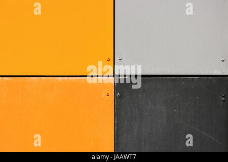 Die Wand des Hauses, garniert mit bunten Platten in hellen Farben gemalt. Grau und Orange. Stockfoto