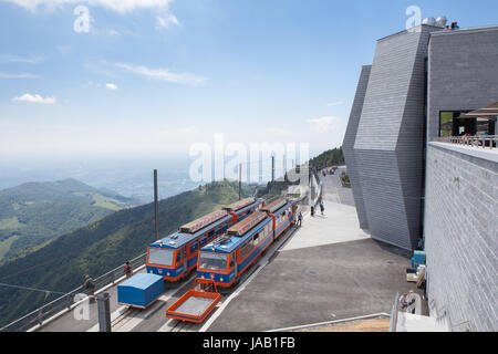 Züge an der Bergstation der Monte Generoso (Monte Generoso) Eisenbahn. Auf der rechten Seite "Il Fiore di Pietra" (die steinerne Blume) designed by Schweizer ar Stockfoto