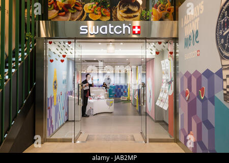 In Osaka Shinsaibashi, Swatch Store, Stoßfänger in Shop suchen, Lächeln männlicher Assistent am Viewer geben Frieden Geste. Stockfoto