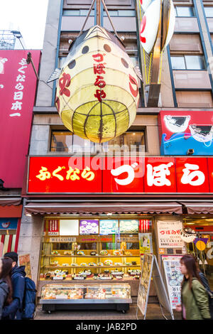 Osaka, Dotonbori. Nacht. Berühmte Kugelfisch Restaurant, Zuboraya, mit riesigen illuiminated Papier lanter Kugelfische, Fugu, hängt über dem Eingang. Stockfoto