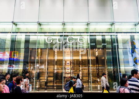 Japan, Osaka Shinsaibashi. Gucci Fashion Store Front. Grün getönte Glas mit Namen über dem Eingang. Menschen zu Fuß durch. Stockfoto