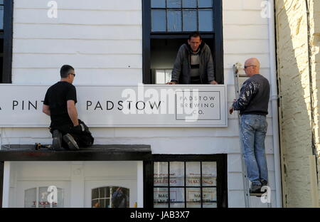 Padstow, Cornwall, UK - 6. April 2017: Arbeiter passend ein neuen Zeichen zum "A Pint von Padstow" Brauerei shop Stockfoto