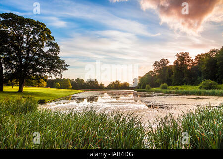 Ein Sommer Sonnenaufgang über dem See bei Lydiard Park in Swindon, Wiltshire. Stockfoto