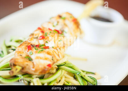 Asiatische Fischgericht mit Julienne-Gemüse, Nudeln und Sauce serviert im stilvollen restaurant Stockfoto