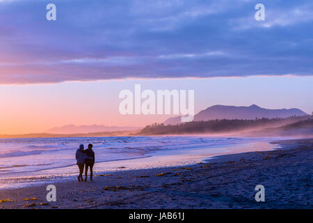 Ein paar schlendern Sie am Strand bei Sonnenuntergang, Pacific Rim National Park, Vancouver Island, British Columbia, Kanada. Stockfoto