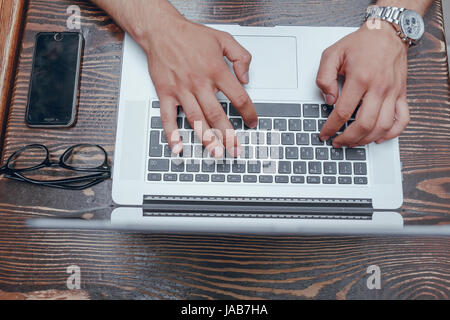 junger Bankangestellter beschäftigt auf einem Laptop in der Mittagspause Stockfoto