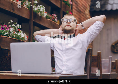 junger Bankangestellter beschäftigt auf einem Laptop in der Mittagspause Stockfoto