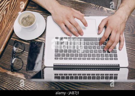 ein junger Bankangestellter beschäftigt auf einem Laptop in der Mittagspause Stockfoto